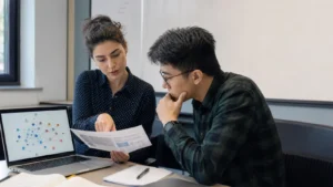 Realistic editorial photograph of postgraduate students comparing cybersecurity and security studies