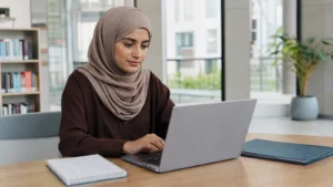 Realistic editorial image of an international student composing a concise professional university email in a bright study area